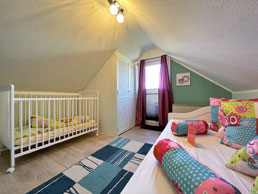Kinderzimmer mit Einbauschrank und Babybettchen